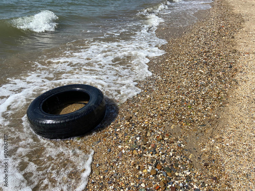 Car tire and pollution on beach