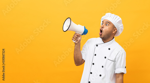 Shout out loud order excited face with mega phone Young handsome asian man boss chef in uniform command order the staff for menu on isolated. Cooking indian man chef in kitchen restaurant and hotel.