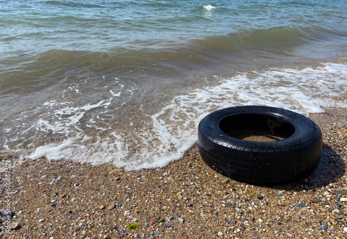 Car tire and pollution on beach