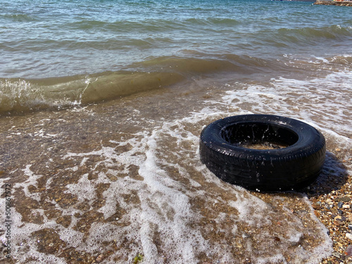 Car tire and pollution on beach