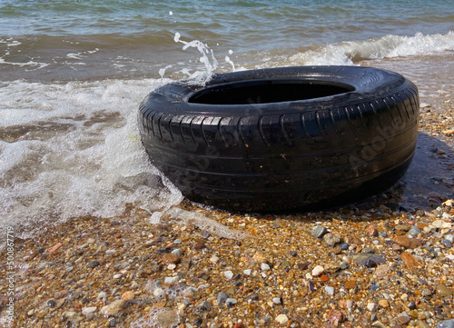 Car tire and pollution on beach