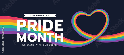 Celebrating pride month - long rainbow pride flag roll made to heart shape on black background vector design photo