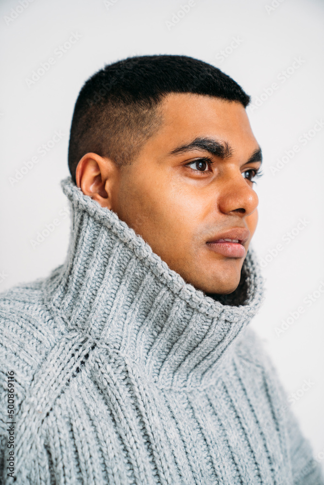 Young man wearing gray sweater against white background