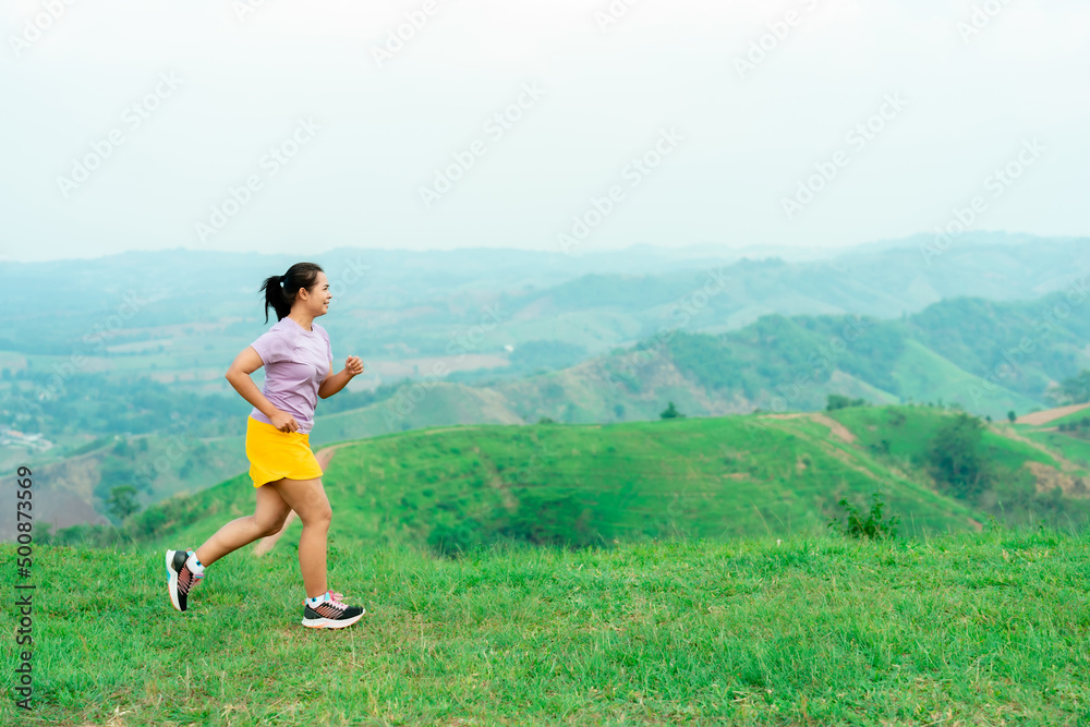 Asian trail runners, women  wearing sportswear are practicing on a high mountain running. During the evening when the air is fresh atmosphere is good.