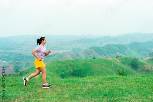 Asian trail runners, women wearing sportswear are practicing on a high mountain running. During the evening when the air is fresh atmosphere is good.
