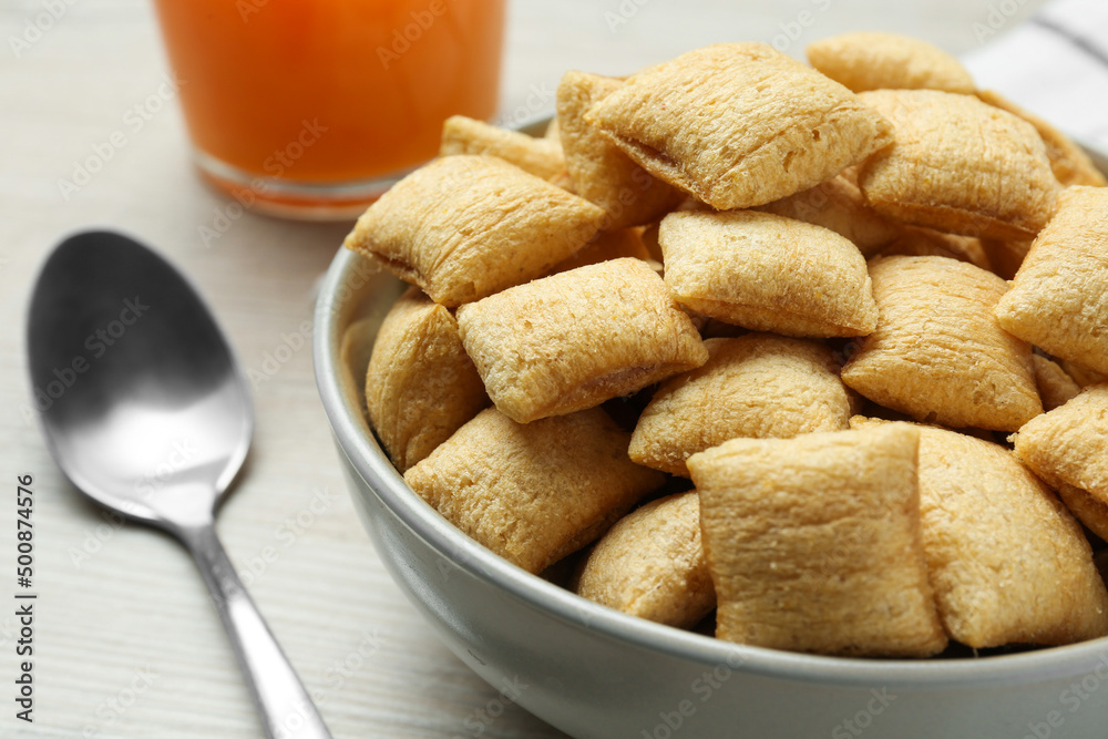 Bowl of sweet crispy corn pads and juice on white wooden table, closeup. Breakfast cereal Bowl of sweet crispy corn pads and juice on white wooden table, closeup. Breakfast cereal