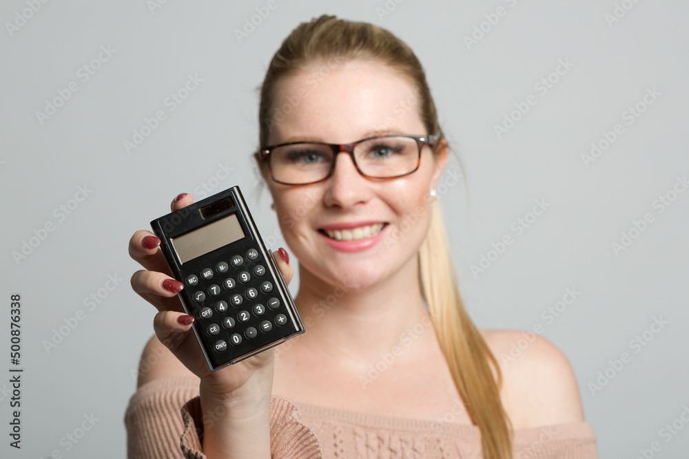 young smiling woman with glasses is presenting a calculator young smiling woman with glasses is presenting a calculator