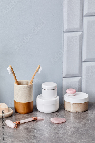 Toilet table in bathroom for woman with cosmetics and mesoroller for face care photo