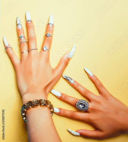 woman hands holding colorful paper copyspace wearing a lot of jewelry and long nails