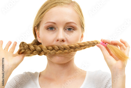 Blonde girl covering her mouth with braid hair