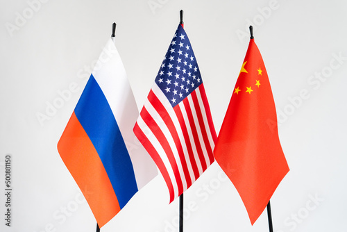 State flags of America, Russia, China on white background. American flag in centre. Conflict concept