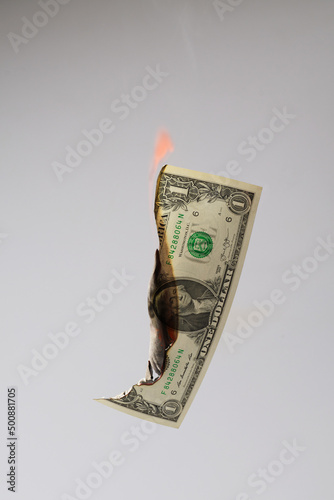 Burning one US Dollar banknote isolated on grey background with visible flame