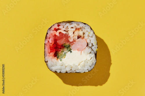 Fresh maki sushi roll on yellow background.