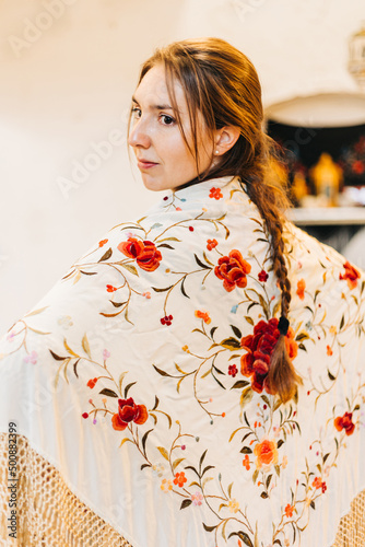 portrait of a beautiful female flamenco dancer with a embroidered floral shawl on her back
