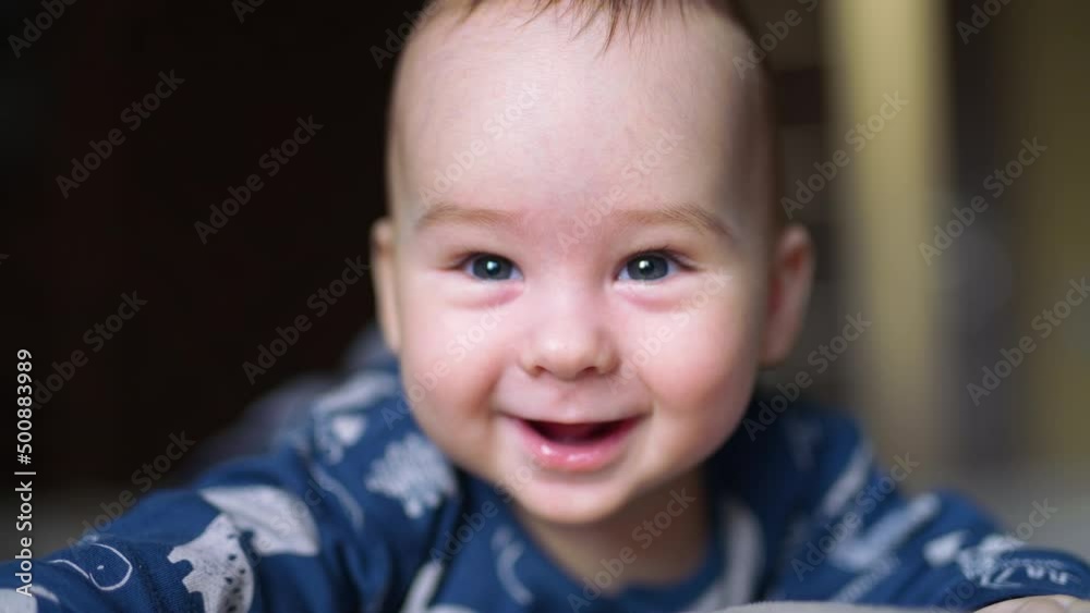 Cute boy looks down with astonishment. Beautiful Caucasian kid smiling with his toothless smile. Close up. Cute boy looks down with astonishment. Beautiful Caucasian kid smiling with his toothless smile. Close up.