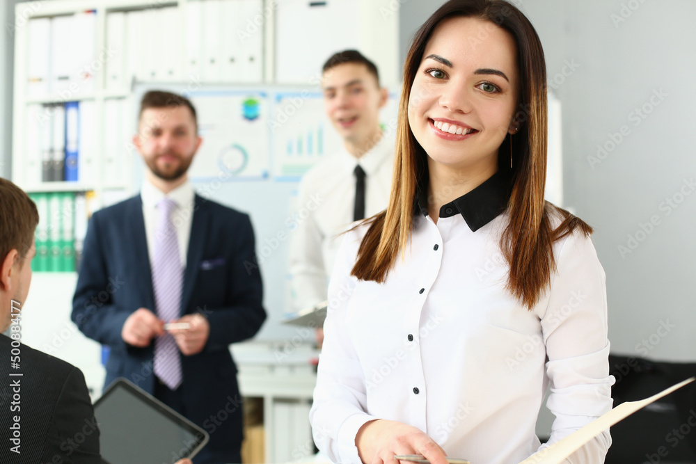 Fototapeta premium Smiling manager posing with colleagues in office, stylish look for work