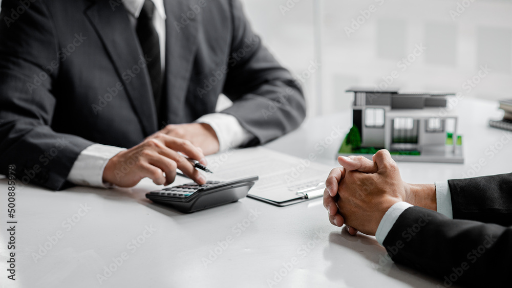 A rental company employee is calculating the cost for the customer to agree to sign a rental contract, explaining the rental terms and conditions. Home and real estate rental ideas. A rental company employee is calculating the cost for the customer to agree to sign a rental contract, explaining the rental terms and conditions. Home and real estate rental ideas.