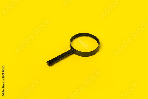 magnifying glass loupe search symbol on yellow background. Top view, flat lay
