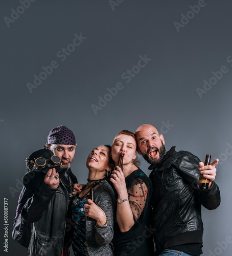 four friends pose on camera in studio shot with cheerful and funny expression