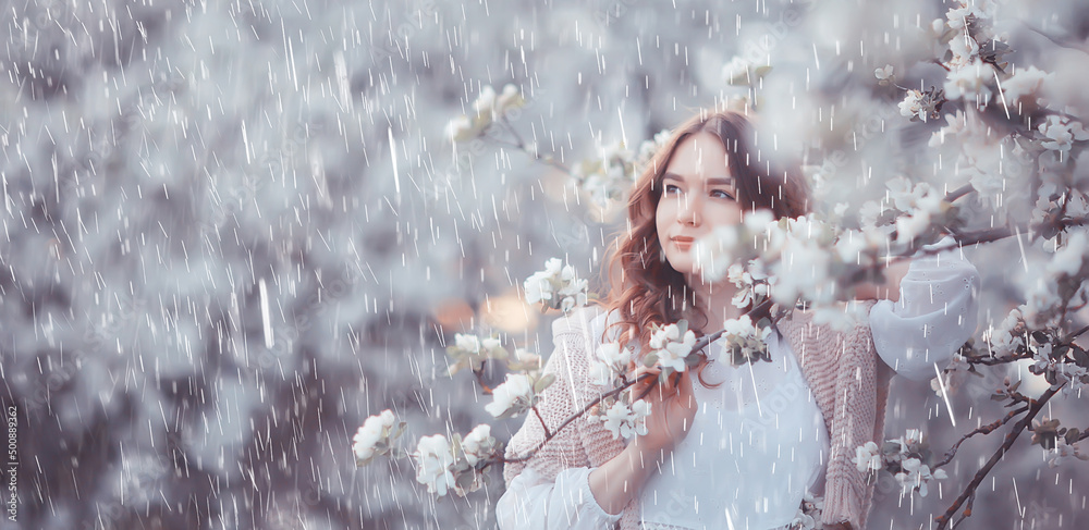 young girl spring portrait in a blooming garden, springtime happiness, rain weather in the park in April young girl spring portrait in a blooming garden, springtime happiness, rain weather in the park in April