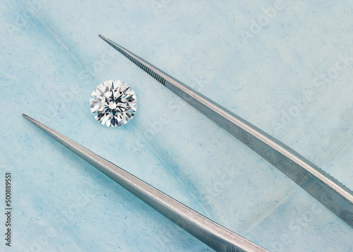 Round Diamond with Tweezers on Blue Background