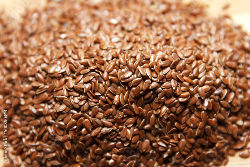 Many linen dry, brown seeds lie on a slide, background