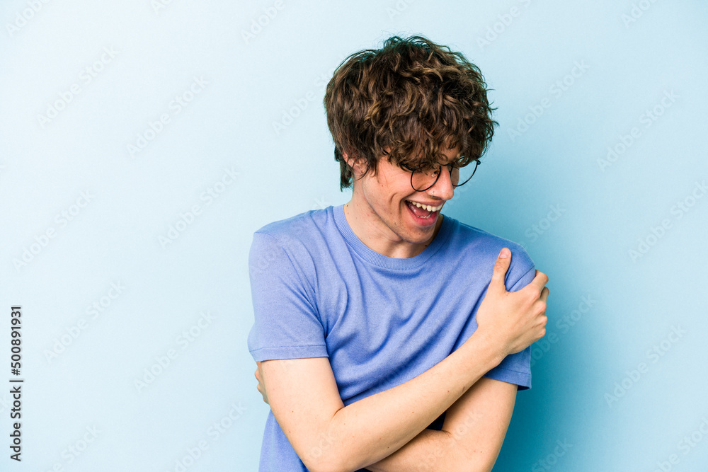 Young caucasian man isolated on blue background laughing and having fun. Young caucasian man isolated on blue background laughing and having fun.