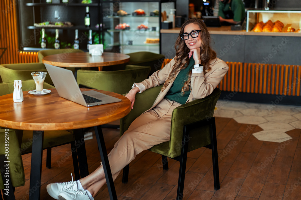 Business Woman Restaurant Owner Use Laptop Dressed Elegant Pantsuit Sitting Table In Restaurant With Bar Counter Background