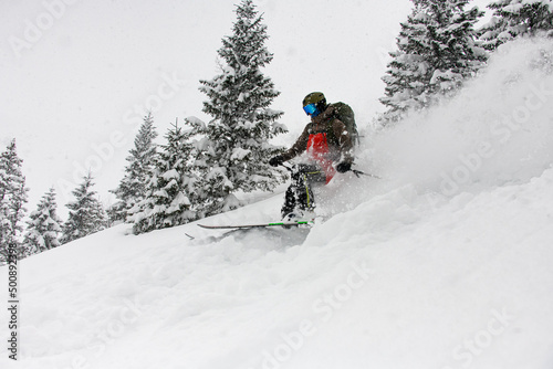 Active skier quickly slides down the snow-covered mountain slope.
