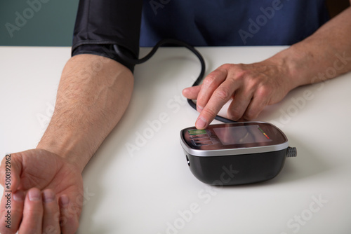 Middle aged man testing his blood pressure at home
