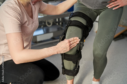 Caucasian woman with orthosis working with physical therapist