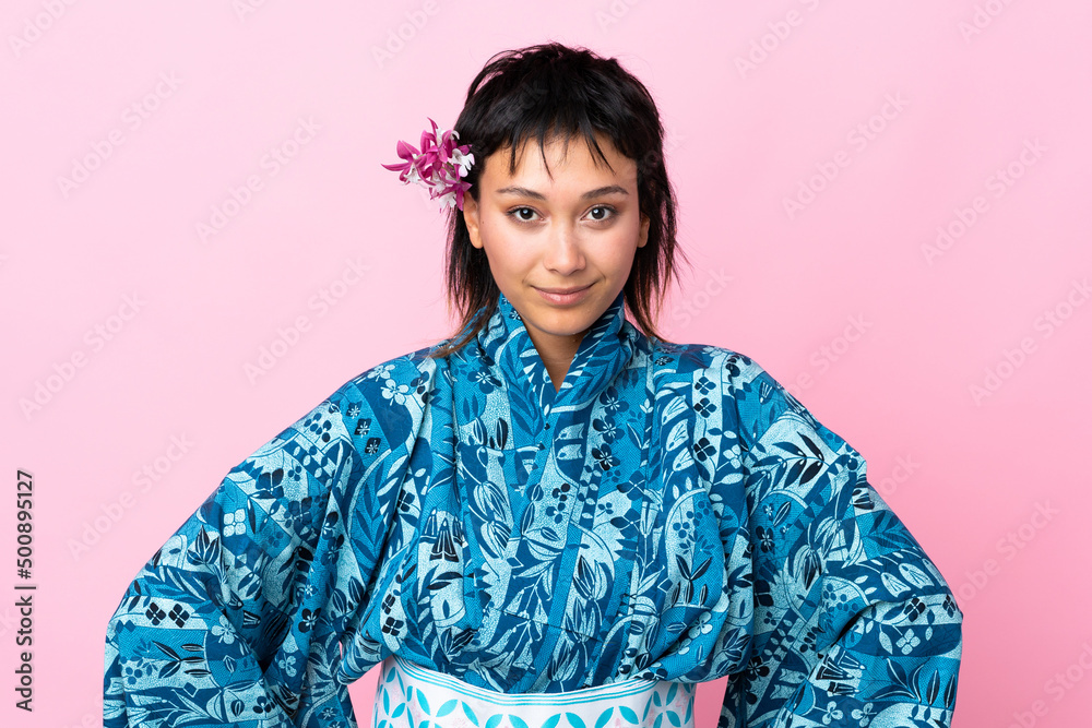 Young woman wearing kimono over isolated pink background Young woman wearing kimono over isolated pink background