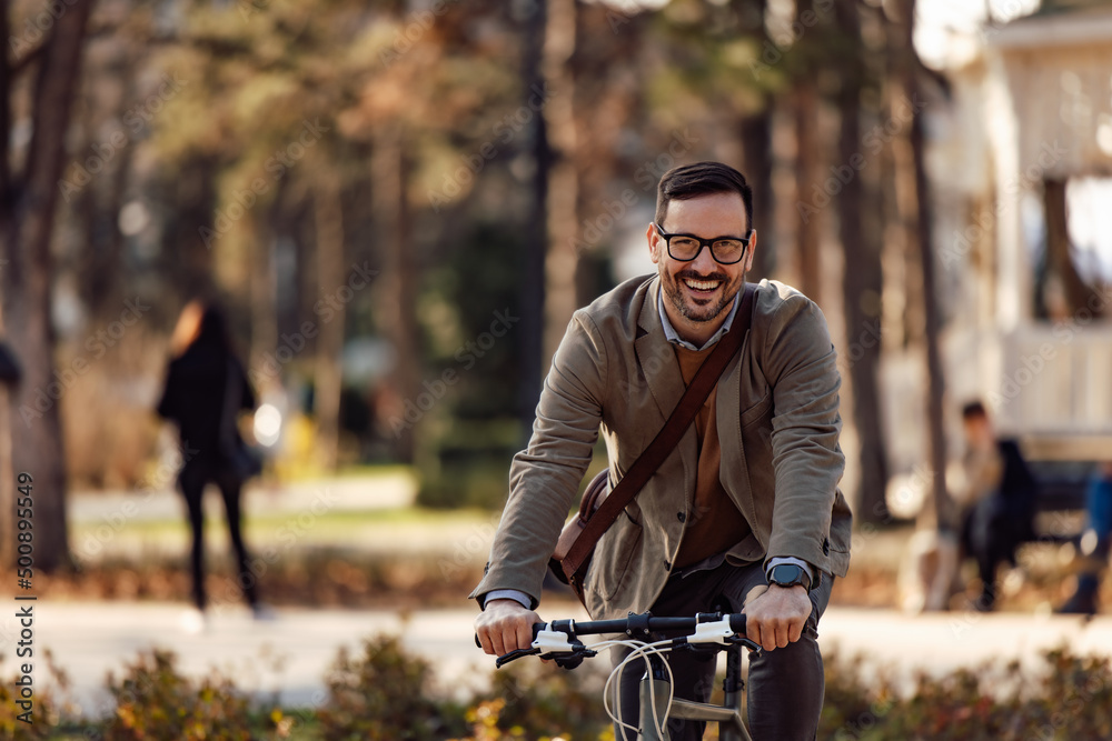 Portrait of a smiling man, riding a bike, looking at the camera.