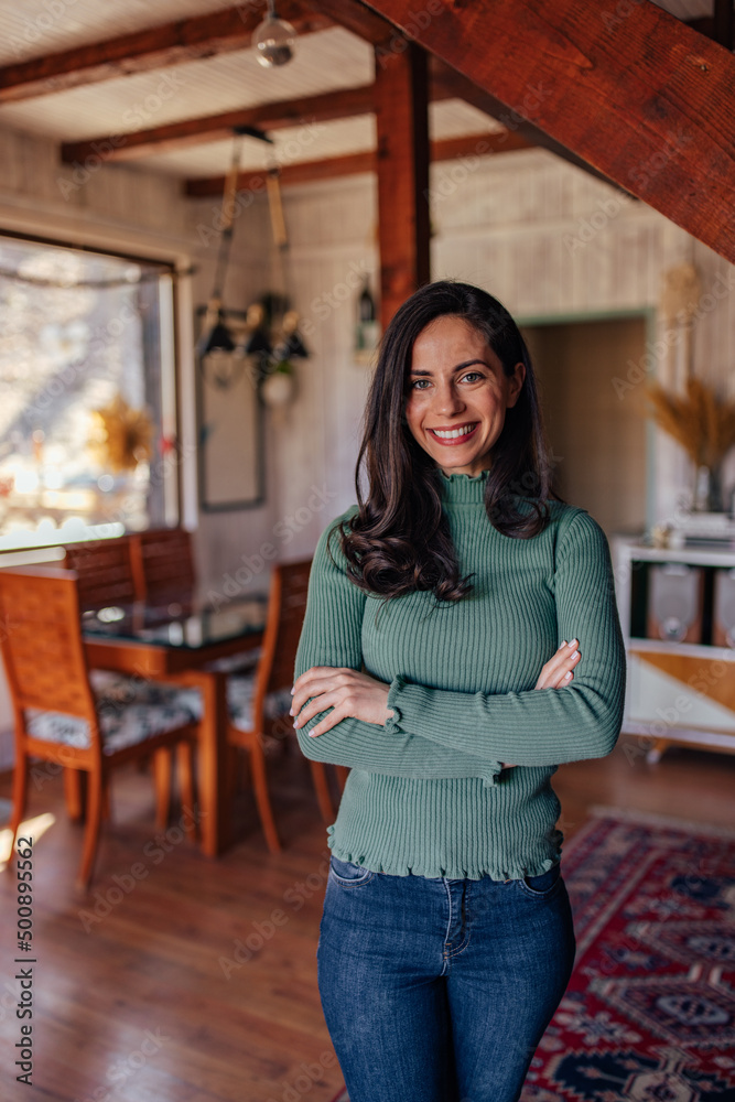 Portrait of a happy woman, dressed casually, relaxed at home.