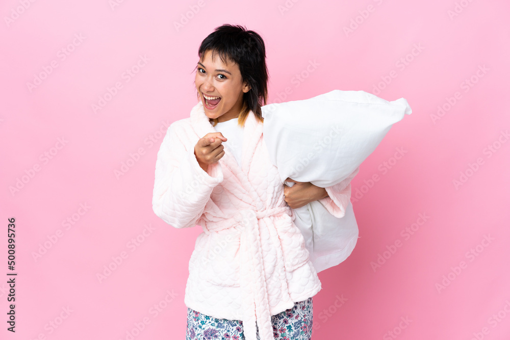 Young Uruguayan woman in pajamas over isolated pink background points finger at you Young Uruguayan woman in pajamas over isolated pink background points finger at you
