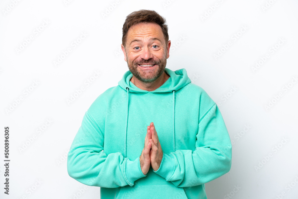 Middle age caucasian man isolated on white background keeps palm together. Person asks for something Middle age caucasian man isolated on white background keeps palm together. Person asks for something