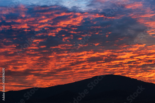Fototapeta Naklejka Na Ścianę i Meble -  Amazing red evening sky and clouds in Beskidy mountains. Orange and yellow sunset. Beautiful sunlight on clouds.