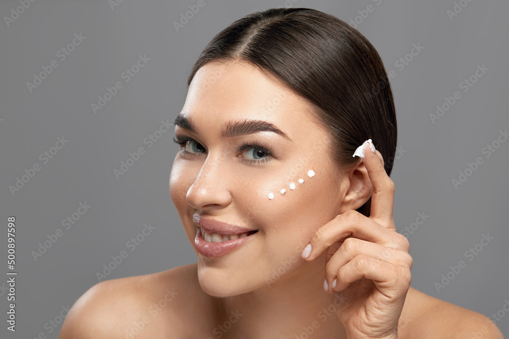 Beauty Woman face Portrait. Beautiful Spa model Girl with Perfect Fresh Clean Skin apply moisturizing cream. Skin care. Facial treatment. Cosmetology. Beauty Woman face Portrait. Beautiful Spa model Girl with Perfect Fresh Clean Skin apply moisturizing cream. Skin care. Facial treatment. Cosmetology.