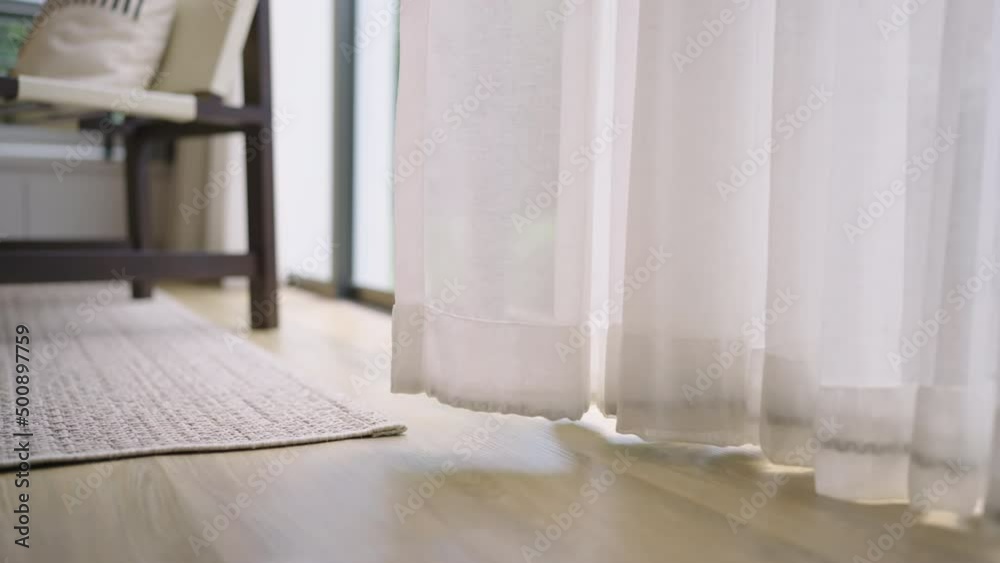 close up white sheer curtain with sun light with shadow shade on wooden floor home interior design concept,cozy home morning light with sun through white curtain window peaceful and clam moment