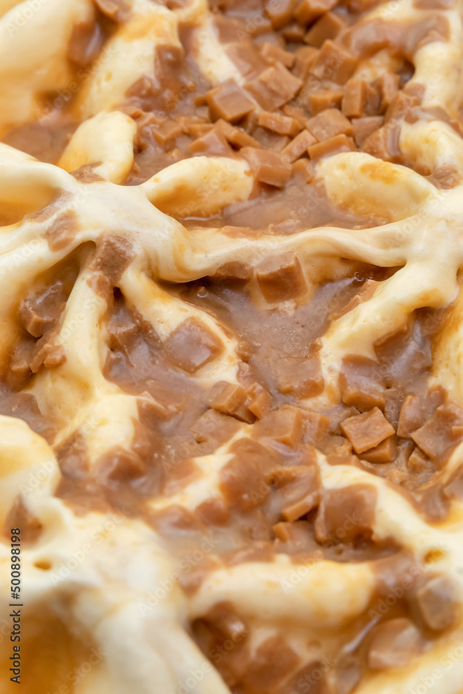 Macro photography of ice cream with caramel. A close-up view of a sweet dessert from above. Abstract food background. Vertical photo Macro photography of ice cream with caramel. A close-up view of a sweet dessert from above. Abstract food background. Vertical photo