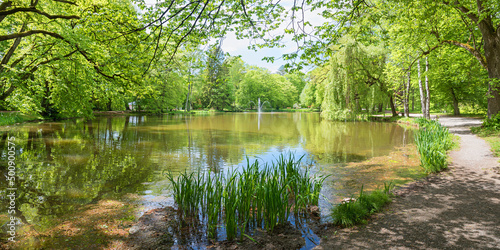 walkway around idyllic pond, Irlacher Weiher, spa garden Bad Aibling at springtime photo