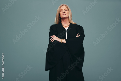 Female judge standing with her arms crossed in a studio photo