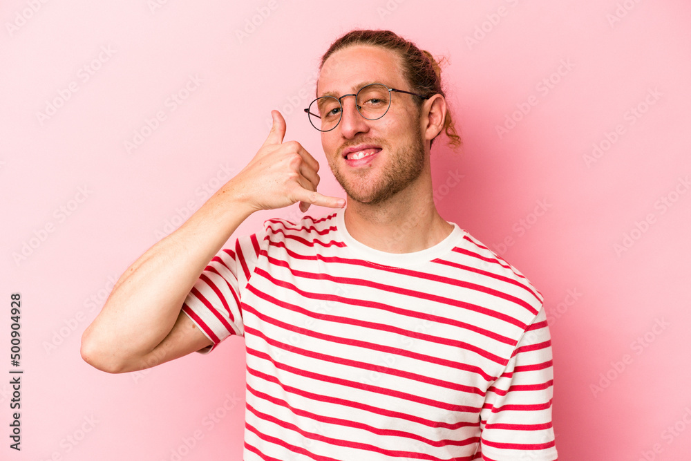 Young caucasian man isolated on pink background showing a mobile phone call gesture with fingers. Young caucasian man isolated on pink background showing a mobile phone call gesture with fingers.