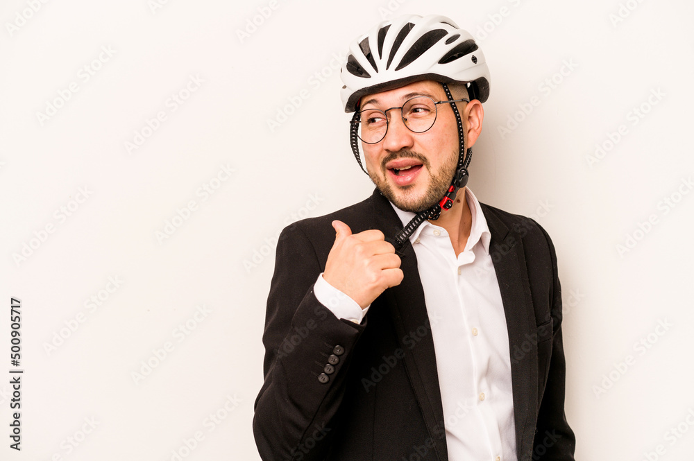 Business hispanic man wearing a helmet bike isolated on white background points with thumb finger away, laughing and carefree. Business hispanic man wearing a helmet bike isolated on white background points with thumb finger away, laughing and carefree.