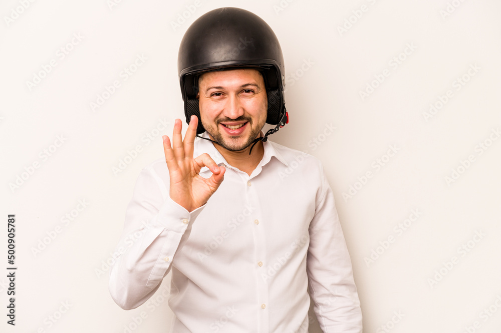 Hispanic business man going to work with motorcycle isolated on white background cheerful and confident showing ok gesture. Hispanic business man going to work with motorcycle isolated on white background cheerful and confident showing ok gesture.