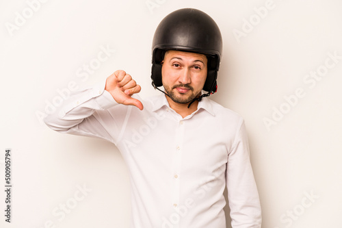 Hispanic business man going to work with motorcycle isolated on white background showing a dislike gesture, thumbs down. Disagreement concept. © Asier