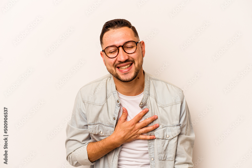 Young hispanic man isolated on white background laughs out loudly keeping hand on chest. Young hispanic man isolated on white background laughs out loudly keeping hand on chest.