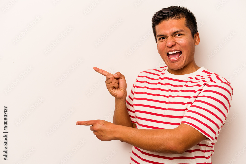 Young hispanic man isolated on white background pointing with forefingers to a copy space, expressing excitement and desire. Young hispanic man isolated on white background pointing with forefingers to a copy space, expressing excitement and desire.