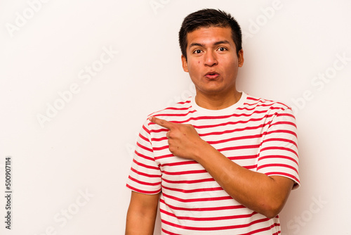 Young hispanic man isolated on white background pointing to the side