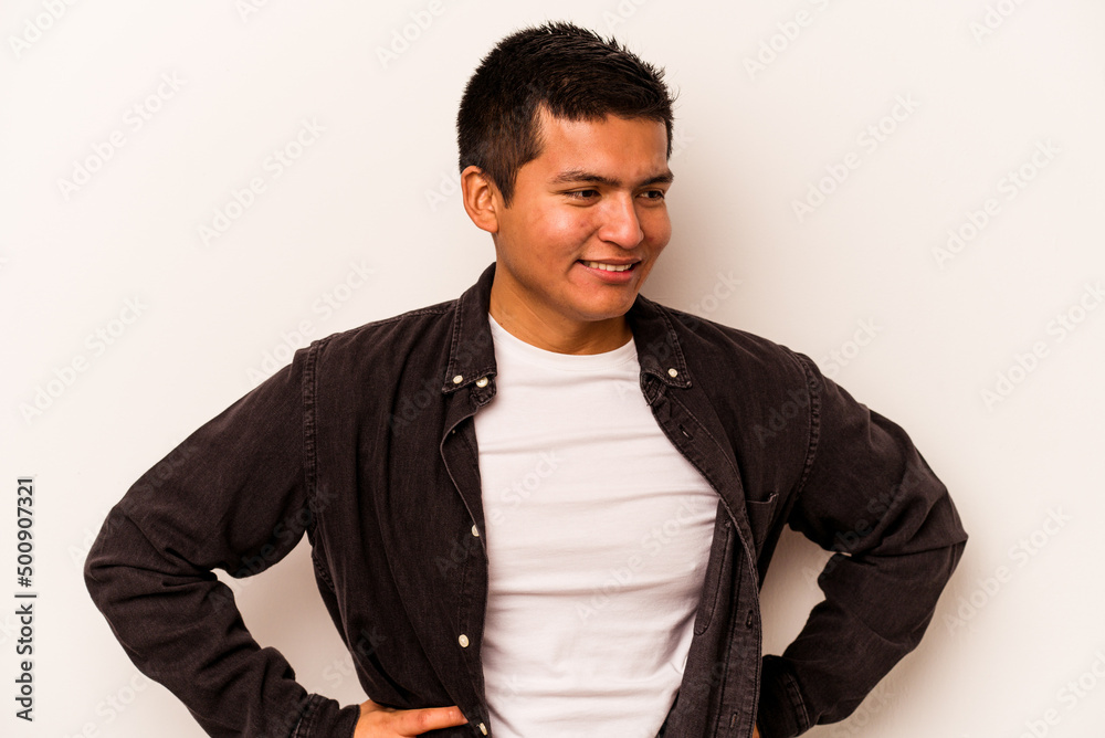 Fototapeta premium Young hispanic man isolated on white background confident keeping hands on hips.